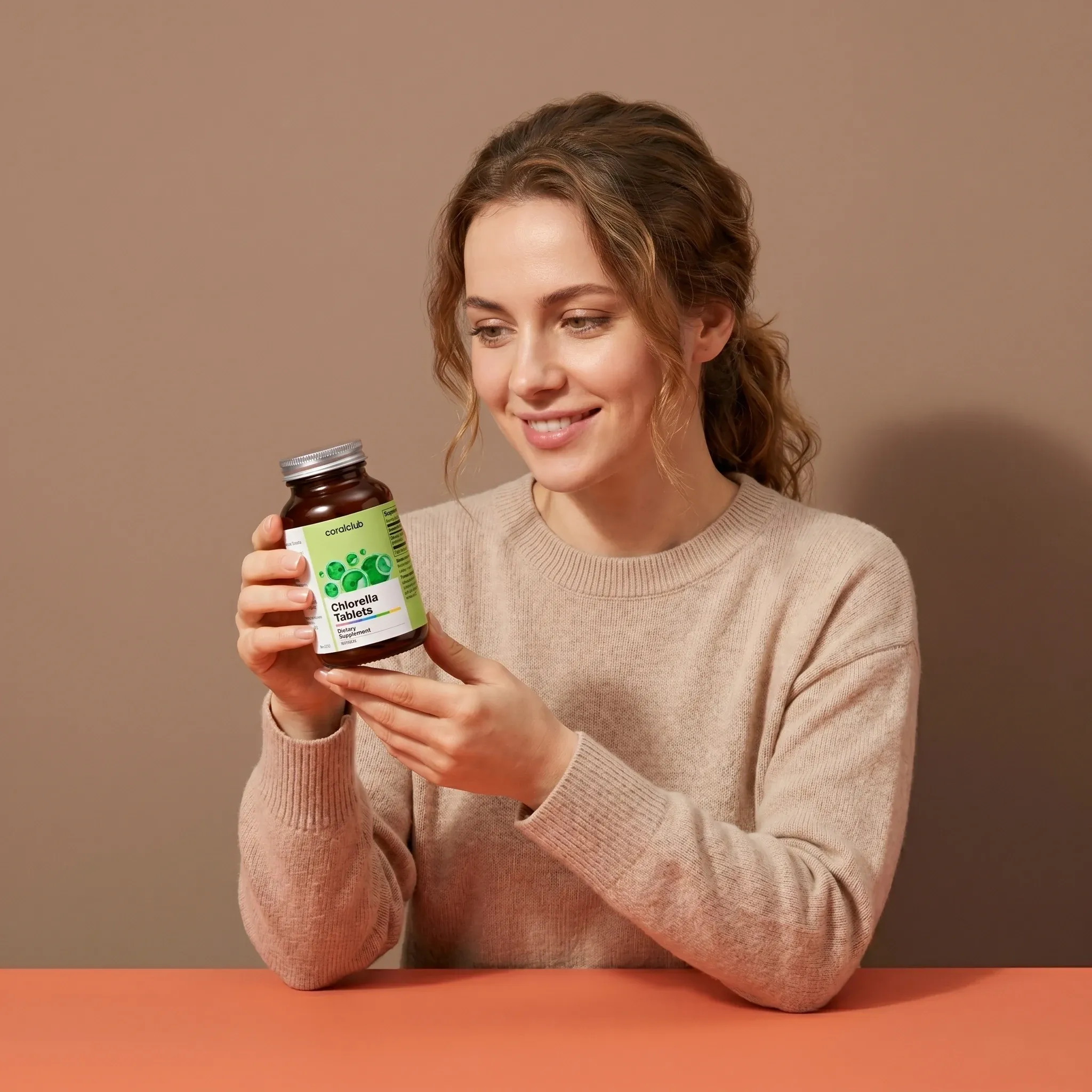 Kobieta trzyma opakowanie produktu Chlorella Tabletki