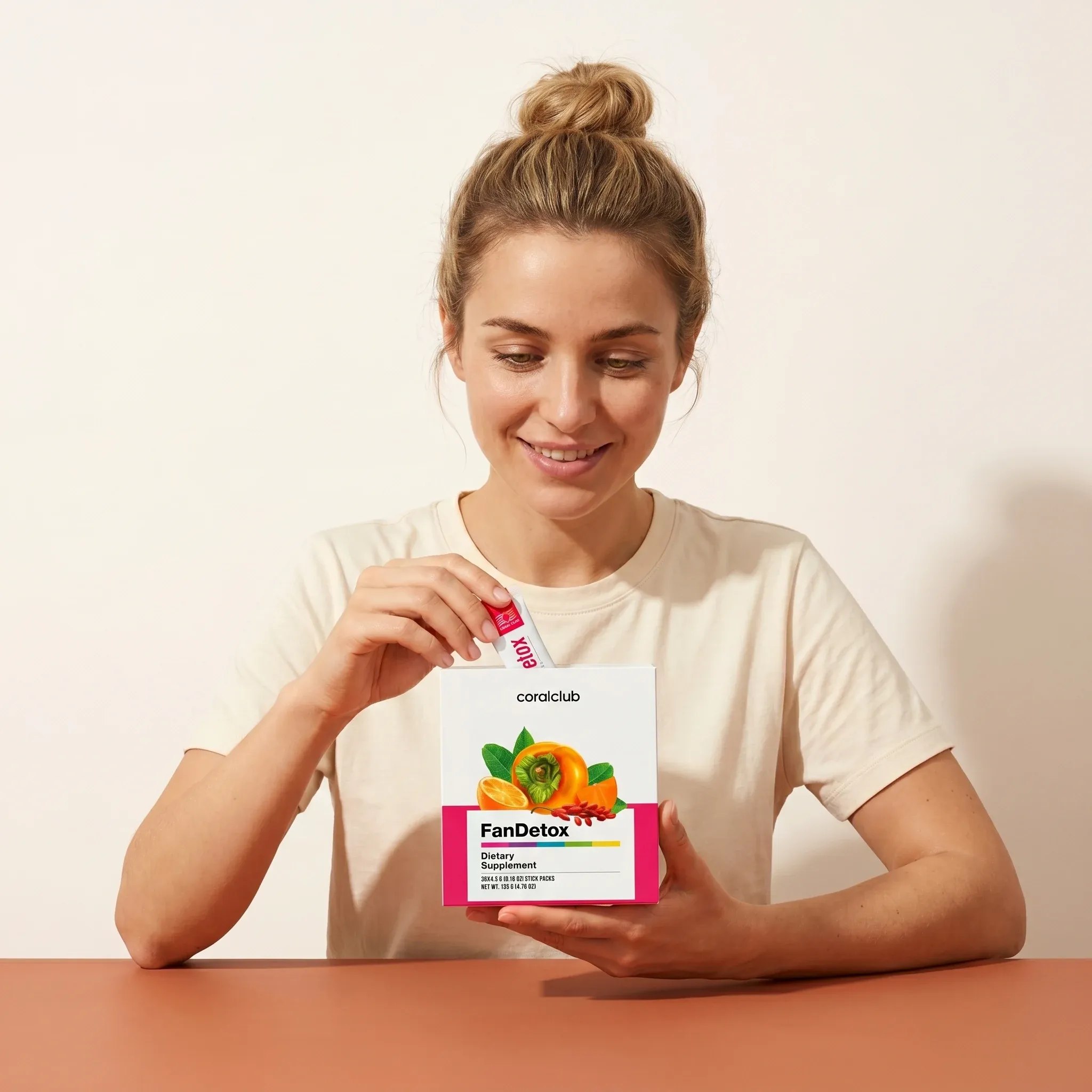 Kobieta trzyma opakowanie produktu FanDetox