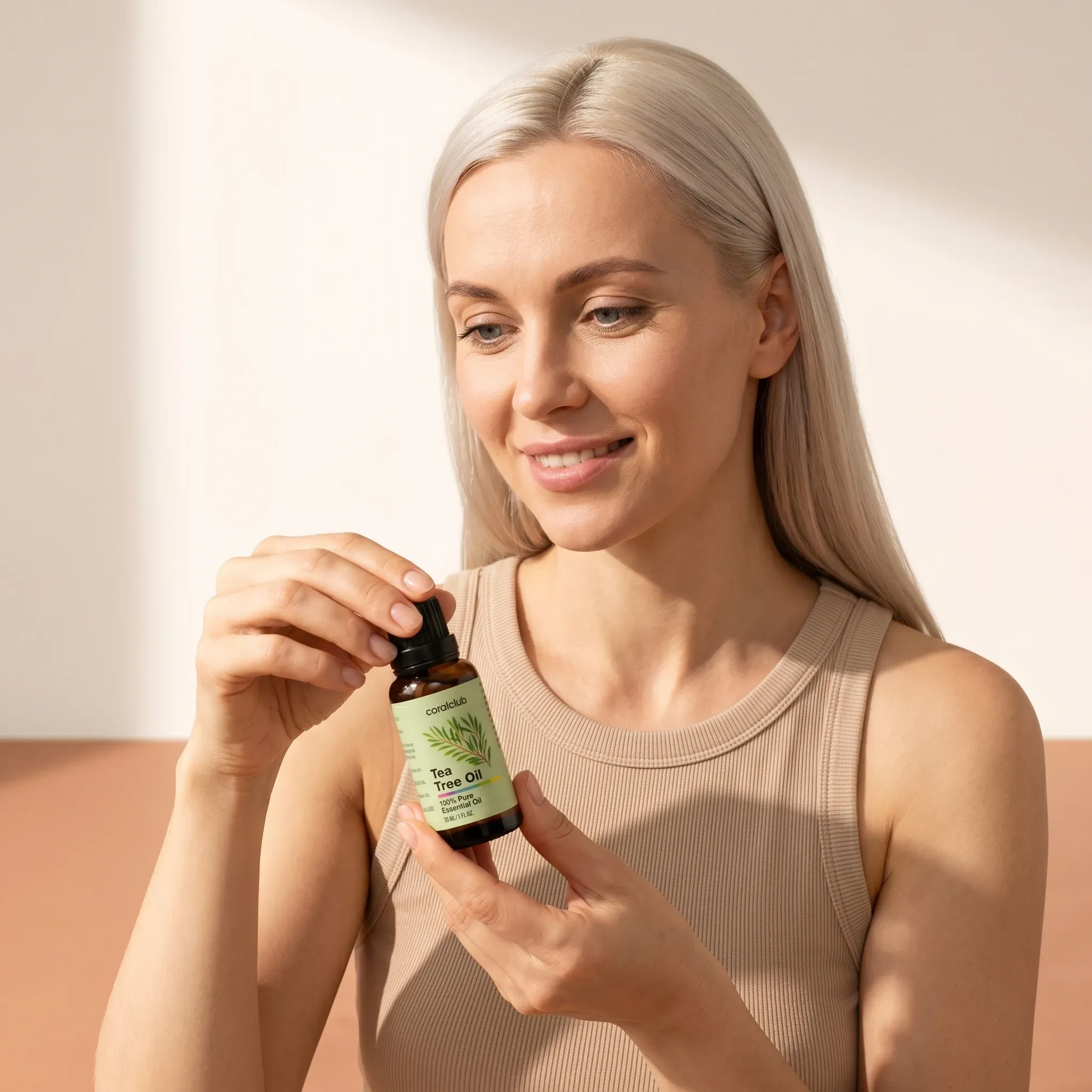 Kobieta trzyma opakowanie produktu Tea Tree Oil